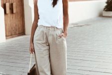 a white sleeveless top, neutral slouchy jeans, tan heels and a black bag for an edgy look