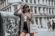 a white tee, a black leather mini, a plaid oversized blazer, white trainers and a pearl bag