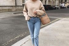 an oversized tan sweatshirt, blue jeans, black shoes, a beret and a basket bag for the fall