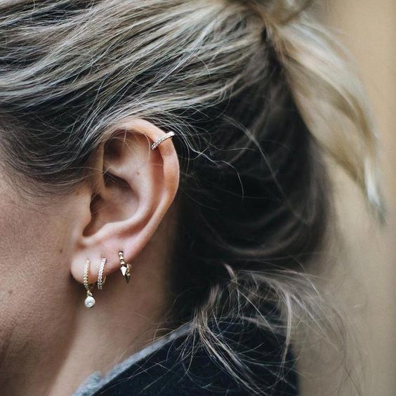 stacked lobe piercings with chic gold hoop earrings and a rhinestone hoop earring for accenting the helix piercing
