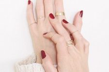 stylish modern gold rings and a delicate midi ring plus a red manicure for a bold look