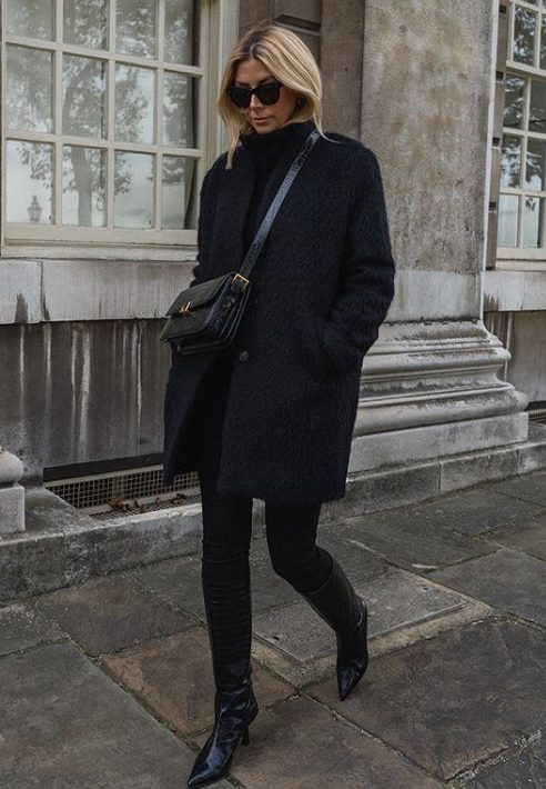 a total black look with a turtleneck sweater, skinnies, reptile print boots and a bag and a short coat