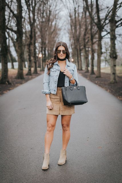 With black top, denim jacket, black bag and gray suede ankle boots