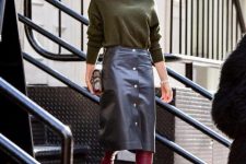 With olive green turtleneck, printed clutch and purple cutout high boots