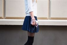 With white sweater, navy blue mini skirt and black boots