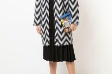 With white turtleneck, black pleated midi skirt, printed clutch and white ankle boots