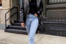 a black turtleneck, blue mom jeans, a black leather jacket and black square toe booties