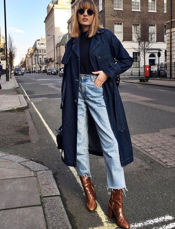 a black turtleneck, light blue raw hem jeans, brown reptile skin booties, a navy denim trench and a black bag