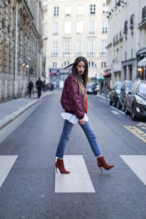 a burgundy bomber jacket, a white shirt, blue jeans, burgundy suede booties for the fall