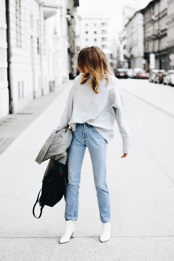 a grey sweater, light blue straight jeans, white booties, a grey coat and a black bag