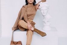 a monochromatic look with a tan turtleneck, gold pants, ocher booties, a tan light coat and an amber bag
