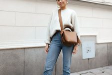 a neutral oversized sweater, blue straight leg jeans, snake print booties and a camel bag