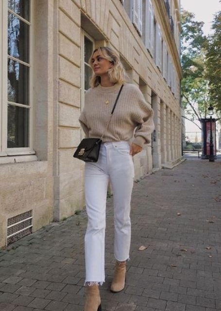 a neutral sweater, white straight leg jeans, tan suede booties and a black crossbody bag