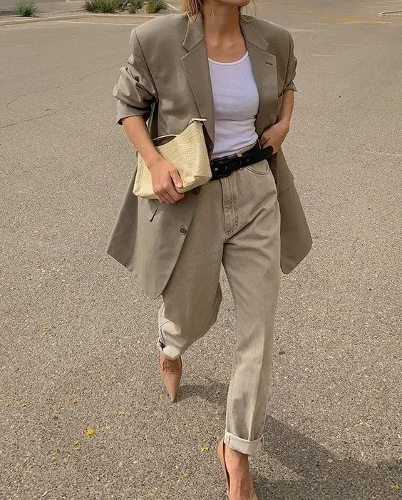 a neutral work look with a white top, an olive green oversized blazer, neutral slouchy jeans, tan heels and a yellow bag