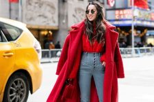 a red blouse, blue high waisted jeans, red shoes, a fuchsia faux fur coat and a red bag