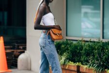 a strapless top, blue jeans, yellow ankle booties, a rust bag and a headband for a bold look