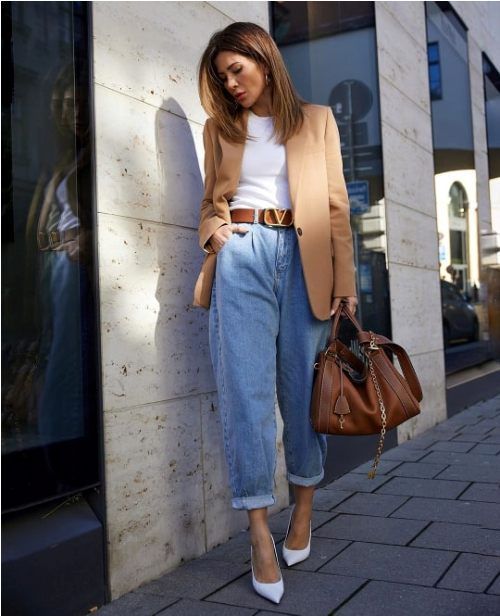 a stylish casual work look with a white top, blue slouchy jeans, white shoes, a tan oversized blazer and a brown bag