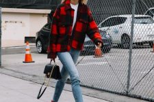a stylish outfit with a white tee, blue jeans, red booties, a black and red shirt jacket and a black bag