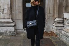 a total black look with a turtleneck, skinnies, black knee boots, a coat, a bag