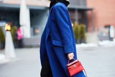 a trendy fall look with a black hoodie, black jeans, black combat boots, an electric blue coat and a red mini bag