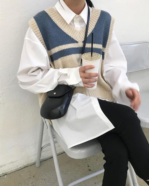a white oversized shirt, a striped oversized knit vest and black skinnies plus a small bag