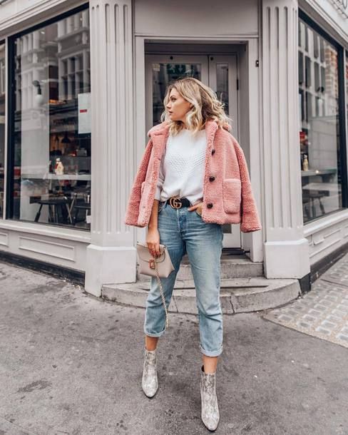 a white sweater, blue cropped jeans, snakeskin print booties, a pink faux fur coat