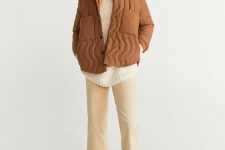 a white sweater, tan pants, white combat boots, a rust-colored cropped quilted jacket