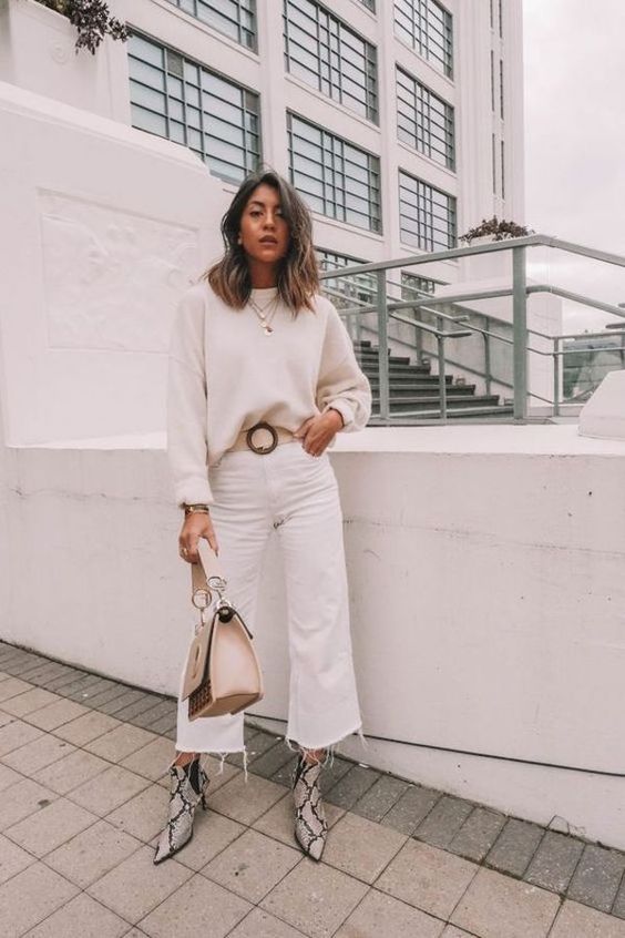 a white sweater, white jeans, snake print booties and a tan bag plus layered necklaces
