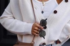 a white tank top, a white oversized cardigan, blue jeans, a camel bag and layered necklaces