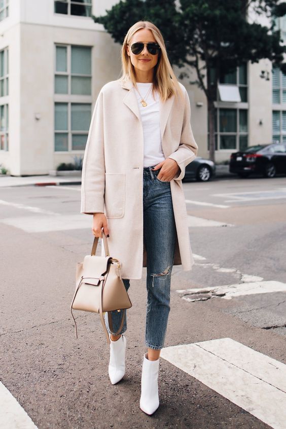 a white tee, blue ripped jeans, white pointed toe boots, a creamy coat and a nude bag