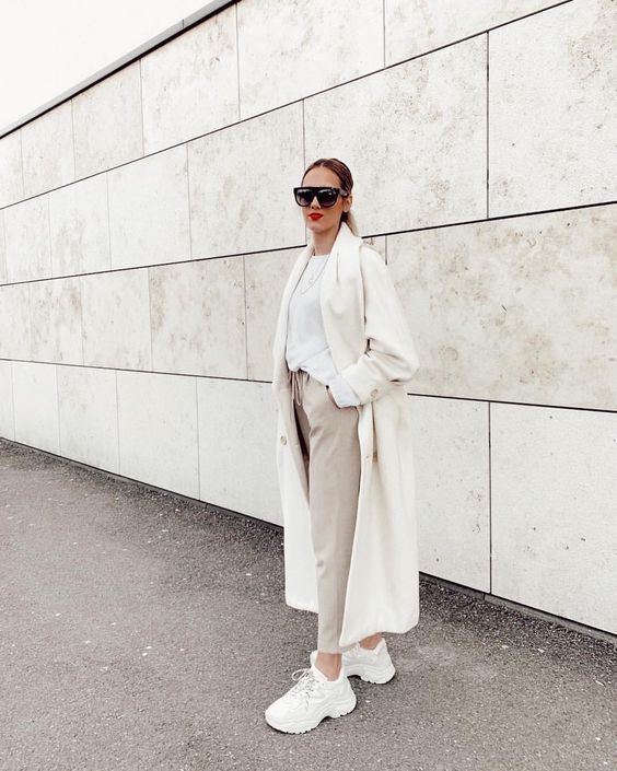 a white top, off-white pants, white trainers, a creamy coat for a chic neutral fall look