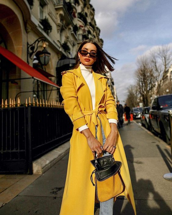 a white turtleneck, blue jeans, a sunny yellow trench and a black and yellow bag for the fall