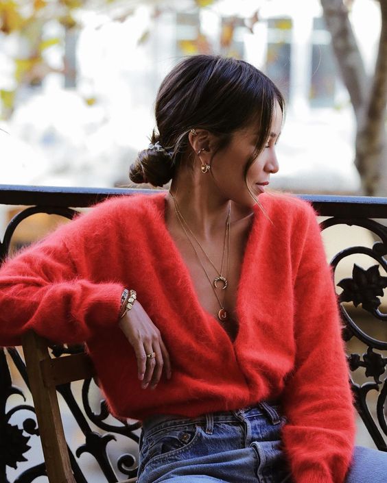 blue jeans, a red fluffy cardigan, layered necklaces and earrings for a bold and sexy fall look