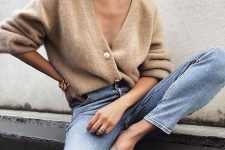 blue jeans, a tan fluffy cardigan and matching mules for an ultimately trendy look
