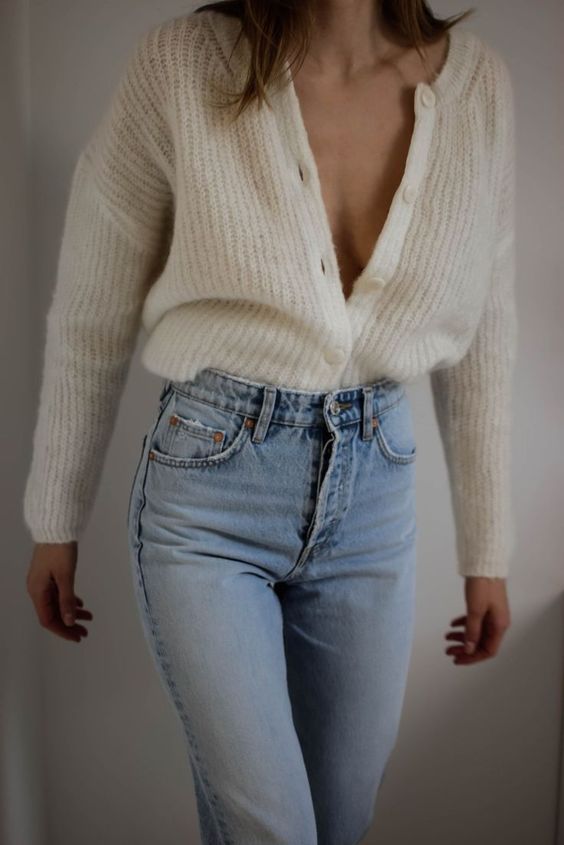 blue jeans paired with a white knit cardigan create a chic and relaxed look for the fall