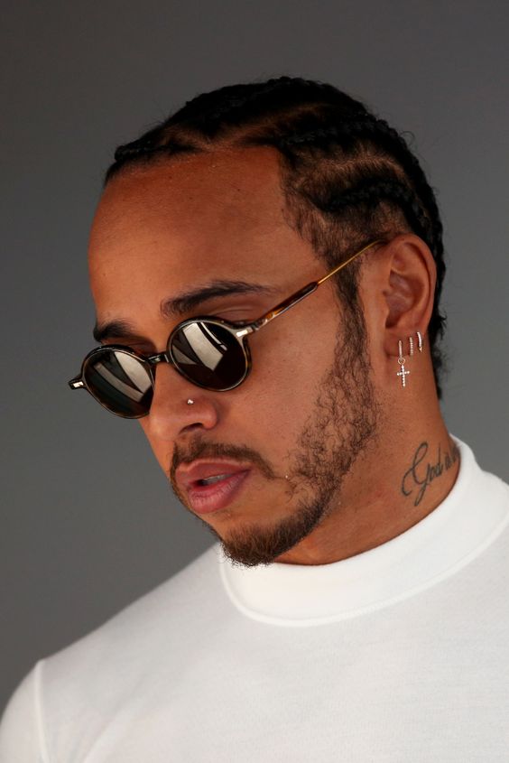 a triple lobe piercing with stylih hoop earrings and a nose piercing with a stud worn by Lewis Hamilton