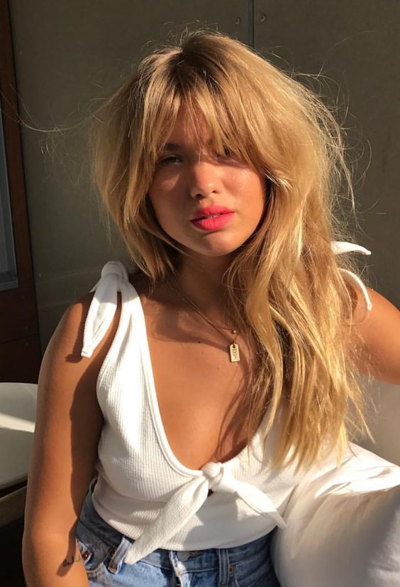long blonde hair with long messy bangs and a messy hairstyle is a chic and sexy thing