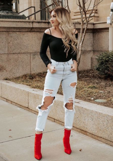 With black off the shoulder top and red suede boots