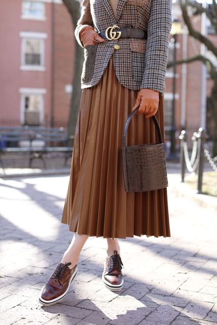 With brown gloves, brown pleated midi skirt, lace up shoes and leather bag