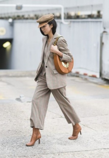 With gray printed suit, brown heeled boots and leather bag