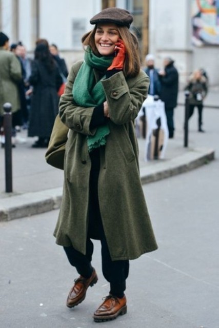 With olive green midi coat, black pants and brown leather shoes