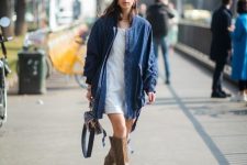 With white dress, navy blue long jacket, bag and printed high boots