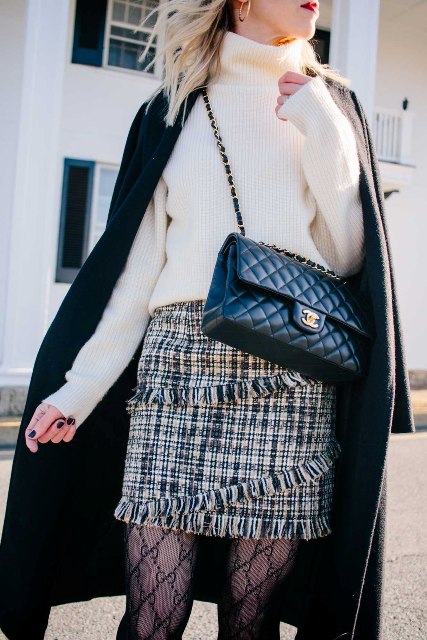 With white sweater, black coat and black leather bag