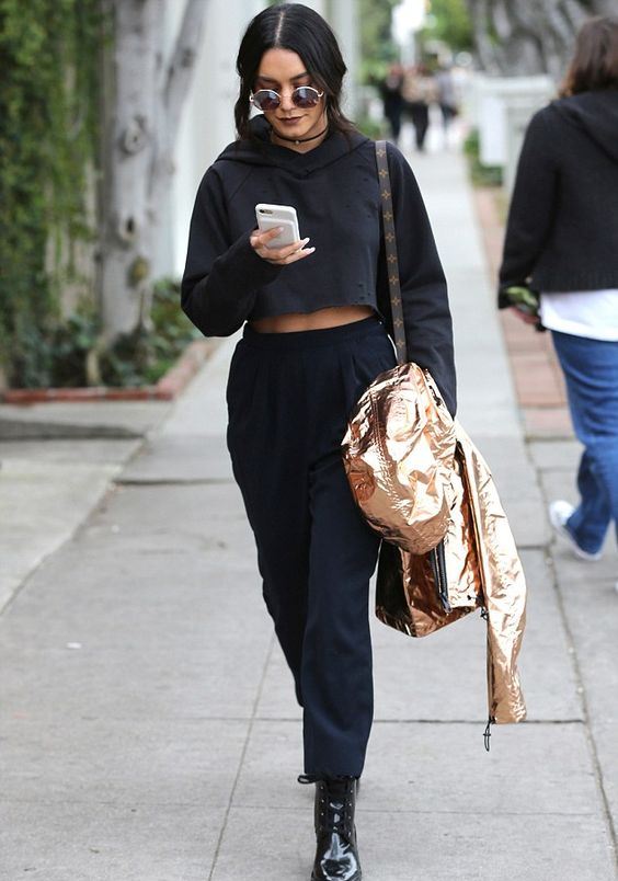 a black cropped sweatshirt, black pants, black lacquer boots and a metallic jacket