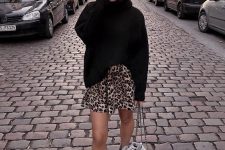 a black oversized turtleneck sweater, a leopard mini skirt, white combat boots and a white bag