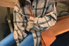a black turtleneck, an oversized plaid flannel shirt and blue skinnies plus a classic amber bag