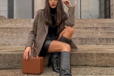 a black turtleneck and a black leather skirt plus boots, a brown woolen blazer, a chain and a brown bag