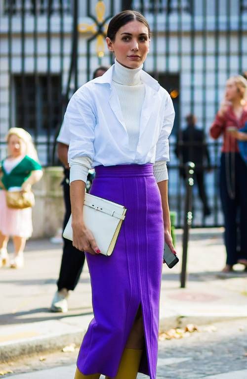 a bold work outfit with a creamy turtleneck, a white shirt, bold purple sheath skirt with a front slirt and a white clutch