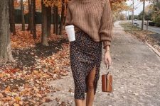 a brown chunky knit sweater with a turtleneck, a moody midi skirt with a slit, white sneakers and a bucket bag