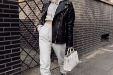 a grey cropped hoodie and joggers, white combat boots, a black leather jacket and a white bag